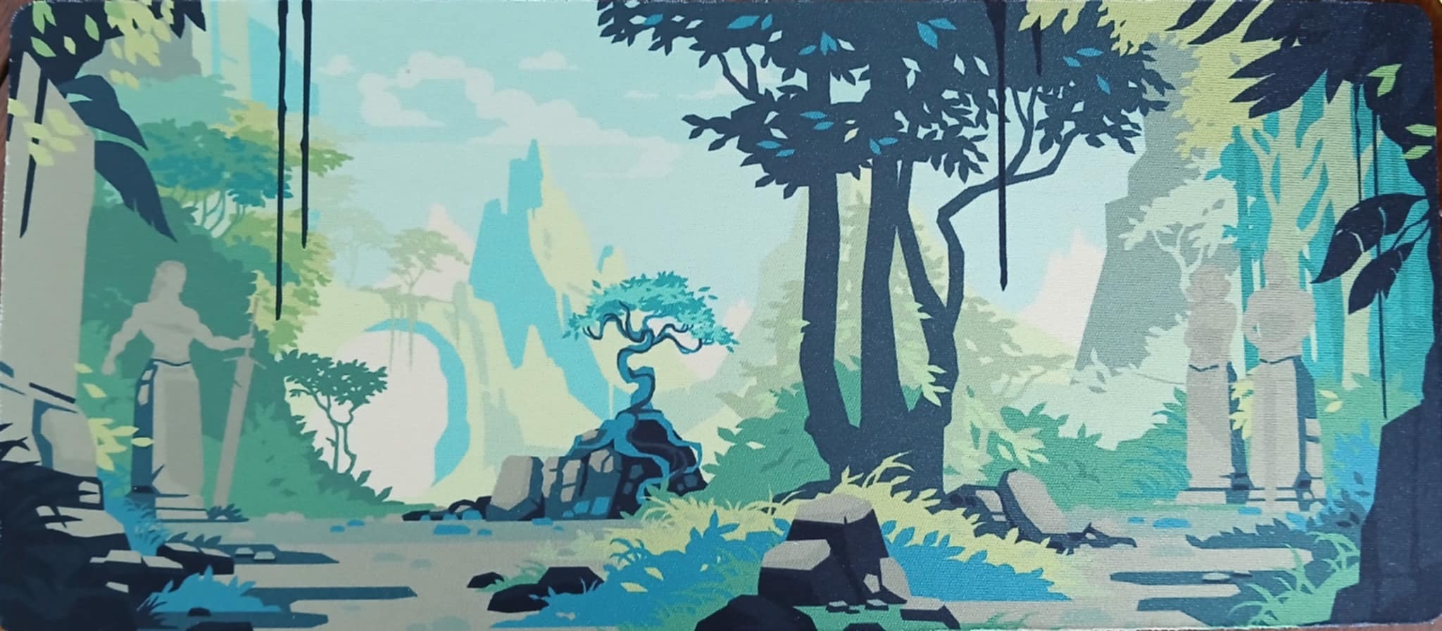 A photo of the green Regicide mat, with a forest landscape and ruined statues.
